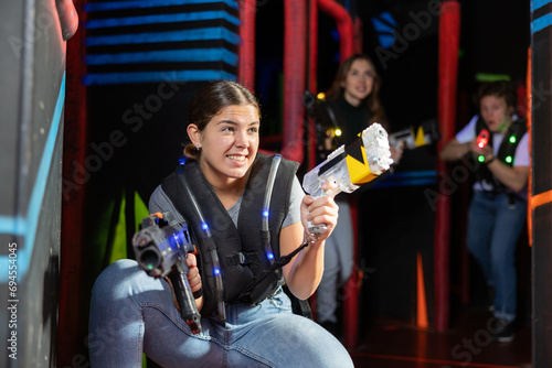 Young woman playing lasertag in arena photo