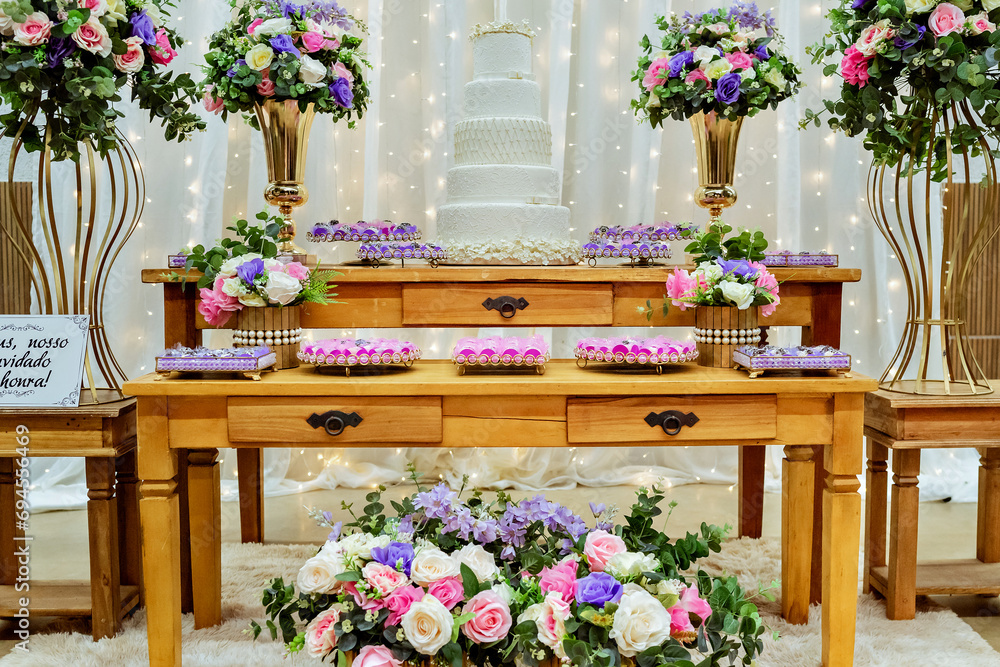 a table decorated with pink, purple and white sweets and flowers