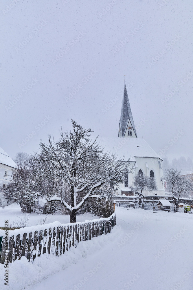 View of snow-covered Bramberg, with the village church in Salzburger Land, Austria,