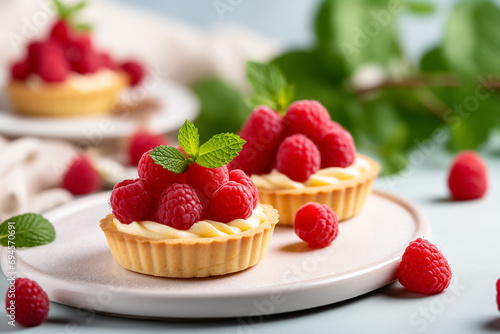 Vanilla tartlets with raspberries on light background photo