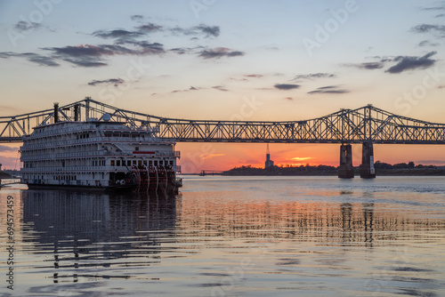 A Paddle Wheeler Cruise Ship at Sunset in Front of the John R Junkin Drive Bridge over the Mississippi River in Natchez, Mississippi 