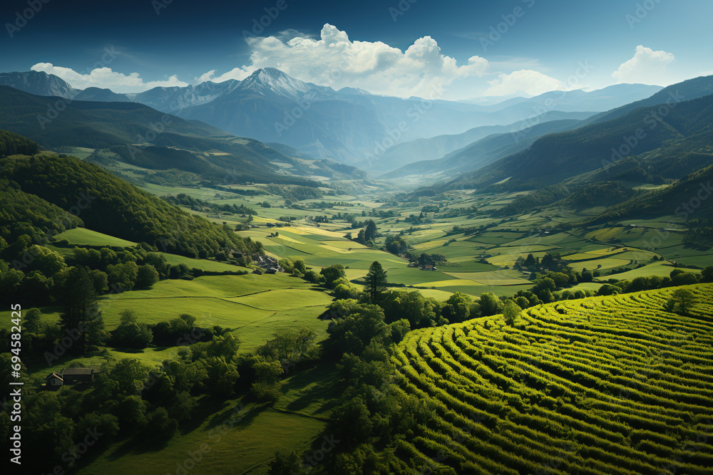 Sunlight bathes a lush green valley with rolling hills and distant mountains, highlighting the tranquil rural landscape.