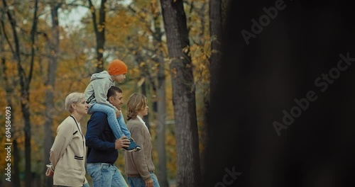 happy married couple and teenagers sons walking in park in autumn day, portrait, 4K, Prores photo