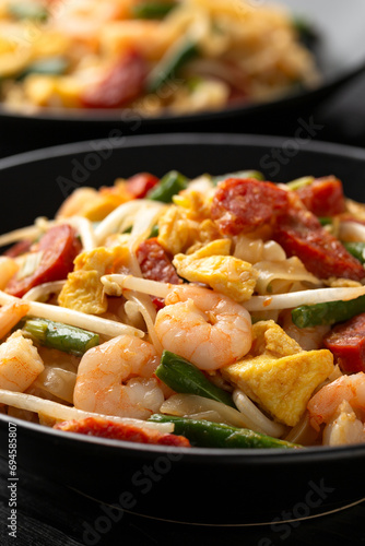 Char kway teow with rice noodles, prawn, sausages, egg and vegetables photo