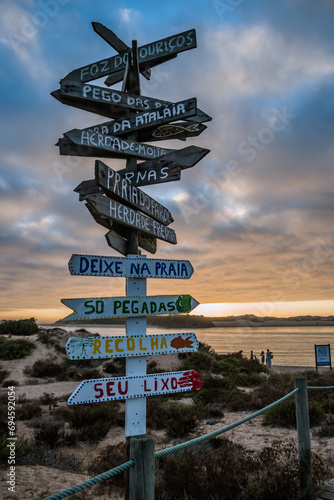 Handmade wooden direction signs of several beaches and respect for the environment at sunset, Milfontes PORTUGAL photo