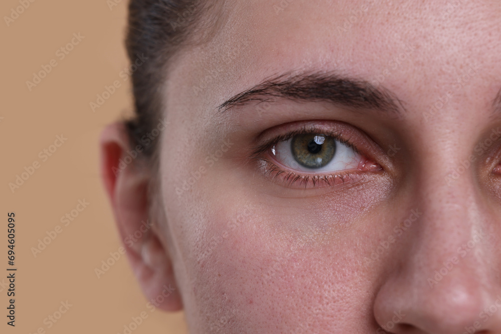 Closeup view of woman with beautiful hazel eyes on beige background Closeup view of woman with beautiful hazel eyes on beige background