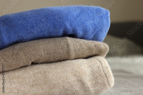 Folded color sweaters on light background, closeup © New Africa