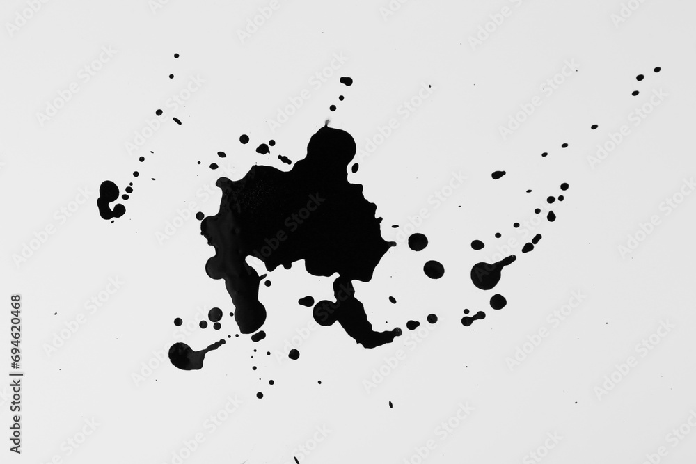 Blots of black ink on white background, top view