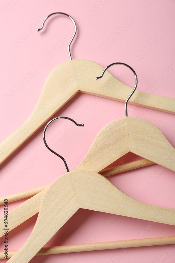 Wooden hangers on pink background, top view Wooden hangers on pink background, top view
