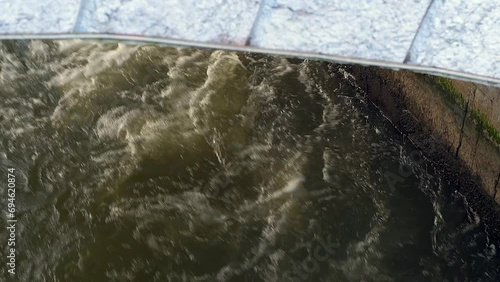 Seething water under the bridge. City river.