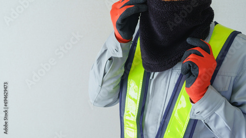 ネックウォーマーで防寒対策をする作業服の男性 photo