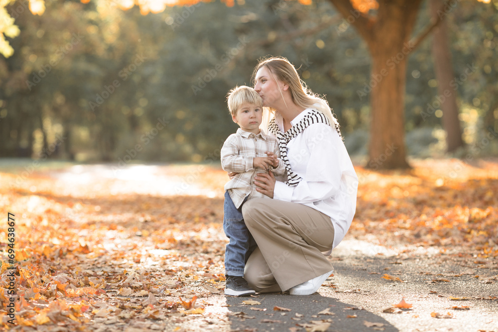 Fototapeta premium Mothers day, love family. Family on autumn walk in nature outdoors. Mother and child with hugging tenderness