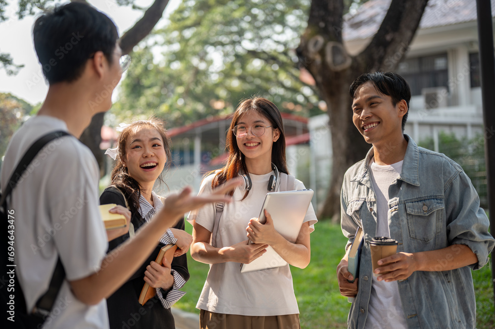 Obraz premium Group of cheerful diverse Asian college students are enjoying talking after classes together.