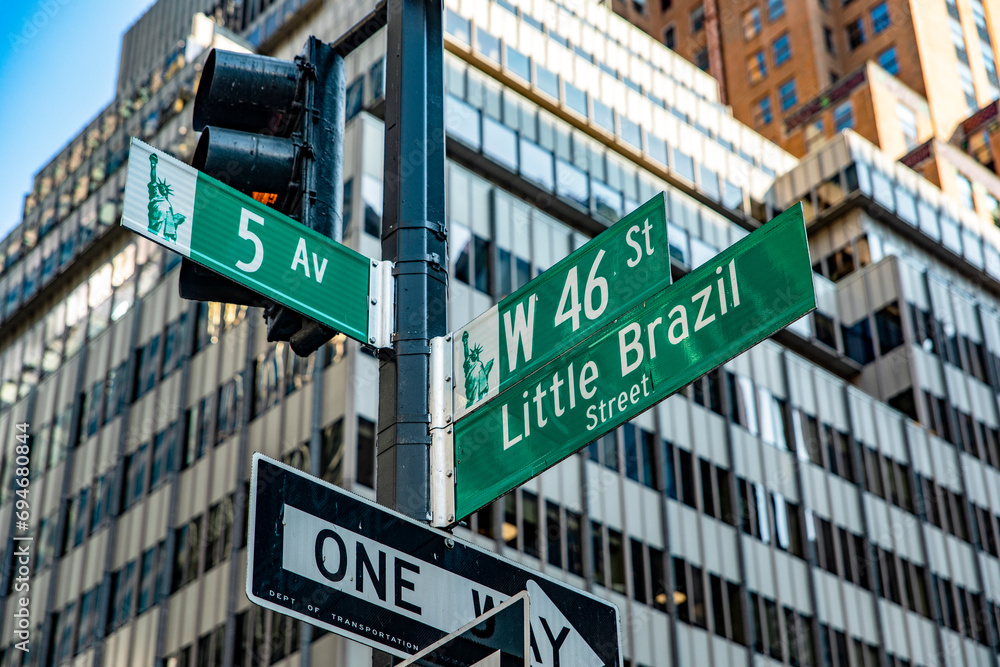 Obraz premium The sign at the intersection of Fifth Avenue and Little Barsil Street, with skyscrapers in the background, is located in the heart of Manhattan, in the heart of the Big Apple of New York in the USA.