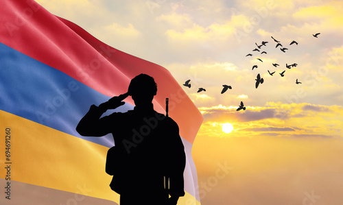 Silhouette of a soldier with the Armenia flag stands against the background of a sunset or sunrise. Concept of national holidays. Commemoration Day. photo