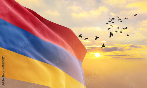 Waving flag of Armenia against the background of a sunset or sunrise. Armenia flag for Independence Day. The symbol of the state on wavy fabric. photo