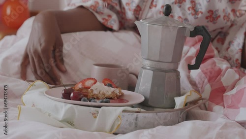 Valentines Day Breakfast in Bed beautiful dark skinned Woman enjoying Viennese Waffles Breakfast with Ice Cream and Fruits. Belgian waffles with ice cream on a plate with coffee on the side. 