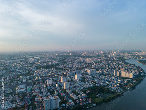 Panoramic view of Saigon, Vietnam from above at Ho Chi Minh City's central business district. Cityscape and many buildings, local houses, bridges, rivers © CravenA