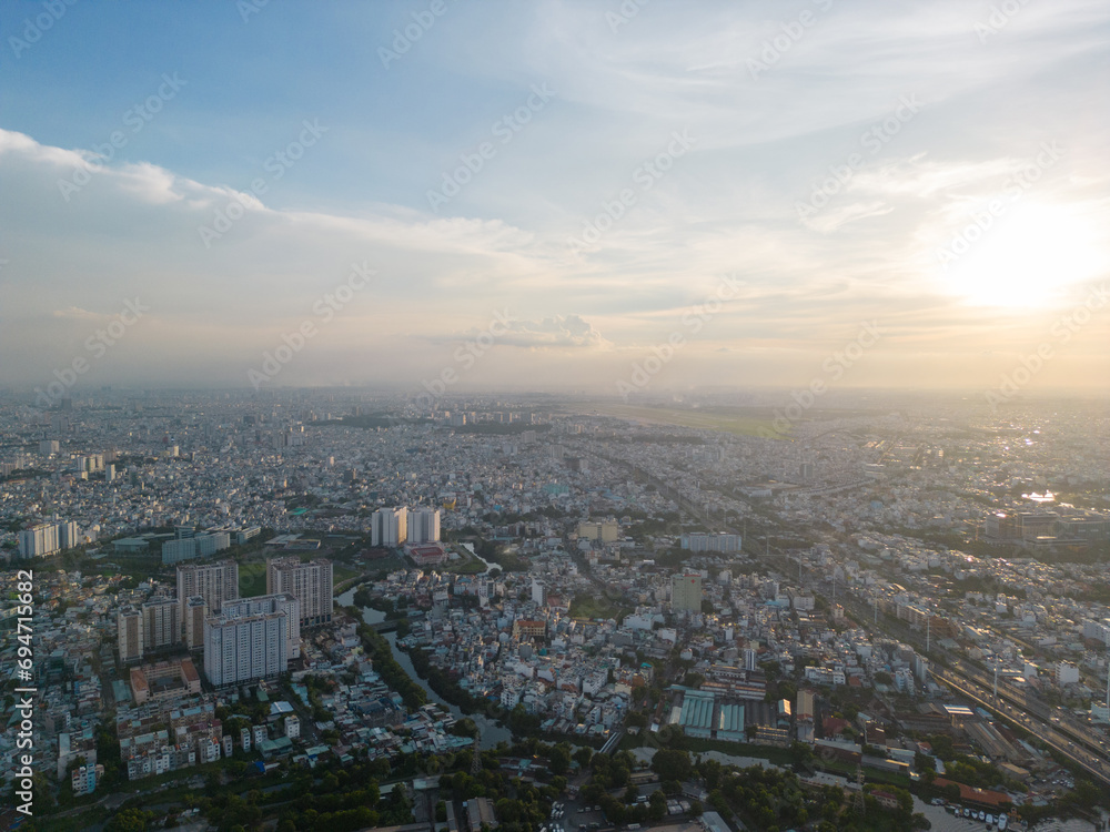 Panoramic view of Saigon, Vietnam from above at Ho Chi Minh City's central business district. Cityscape and many buildings, local houses, bridges, rivers