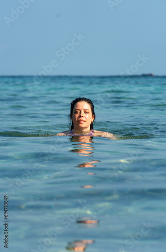 Portrait of pretty young woman swimming in the ocean