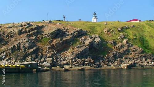 Landscapes of the Snake Island -a rocky slope, a lighthouse is visible on the top of the island. Black Sea, Ukraine. photo