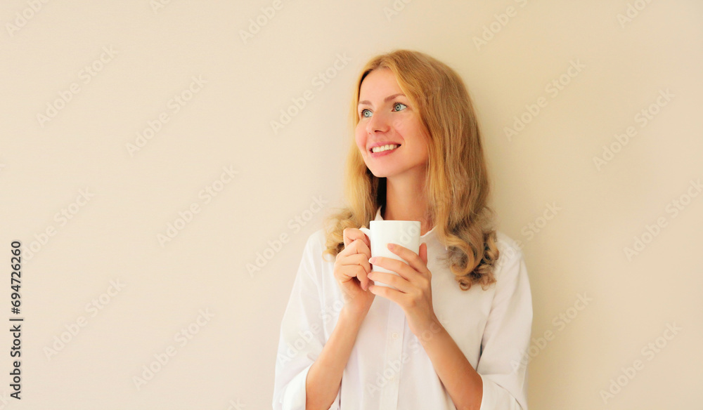 Portrait of happy satisfied smiling young woman enjoying hot tasty cup of coffee or tea in early morning at home Portrait of happy satisfied smiling young woman enjoying hot tasty cup of coffee or tea in early morning at home