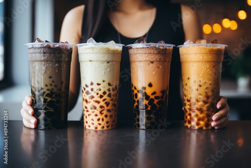 Woman holding four different types of bubble tea, boba tea asian trendy beverage