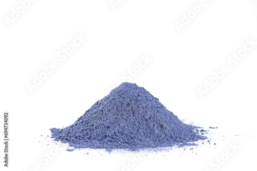 Heap of dry blue matcha powder from clitoria flowers on a white background.
