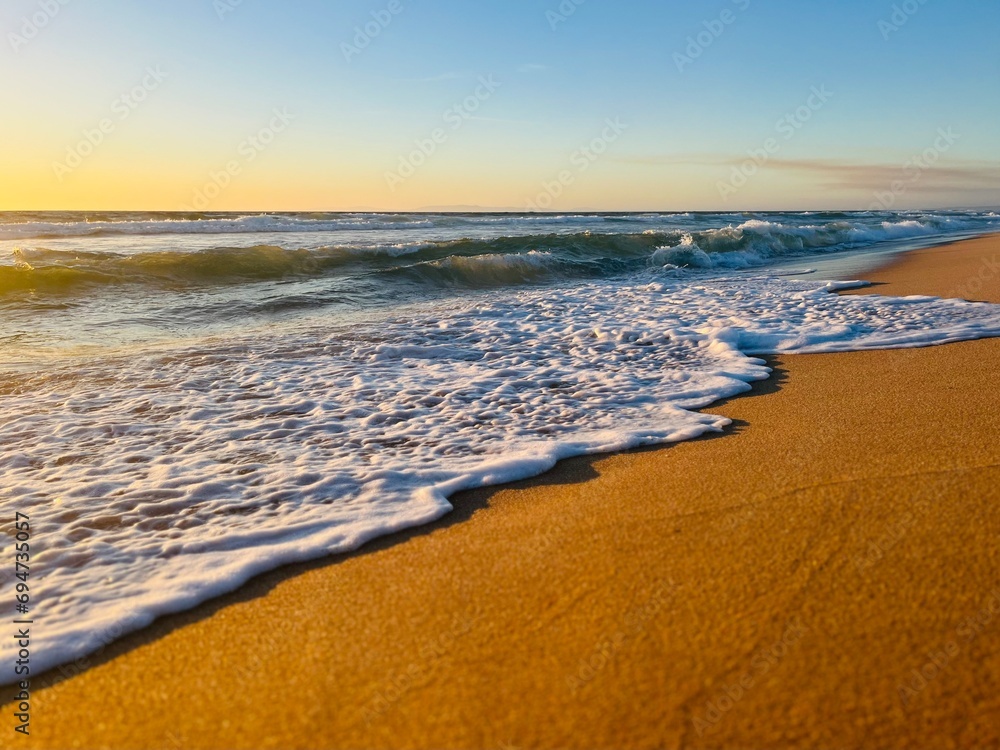 Sandy ocean shoreline, empty beach, warm evening light Sandy ocean shoreline, empty beach, warm evening light