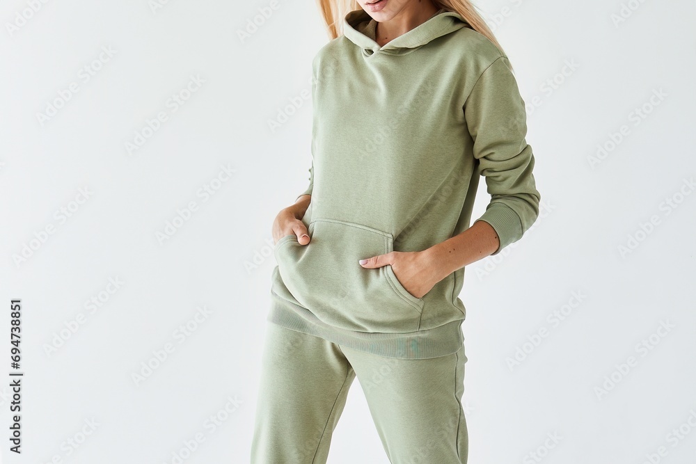 Girl wears a light green hoodie and pants. Horizontal studio shot for sports clothing sale. Casual Elegance in Green – A Model Showcasing a Stylish and Comfortable Outfit Perfect for Everyday Wear Girl wears a light green hoodie and pants. Horizontal studio shot for sports clothing sale. Casual Elegance in Green – A Model Showcasing a Stylish and Comfortable Outfit Perfect for Everyday Wear