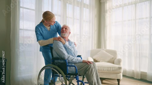 Doctor hold caring hands on shoulder of sad elderly patient.Physician help support disabled retired man patient.Nurse supports the sick man and puts hand on shoulder is grateful.Caring and empathy photo