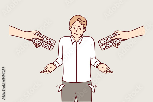 Poor man cannot buy medications and shows empty pockets, standing among hands with blisters of pills. Guy does not have money to purchase antibiotics and medications to treat or prevent disease