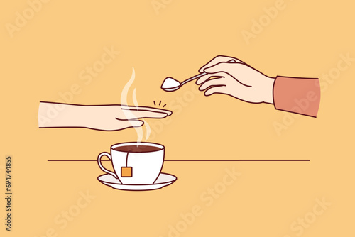 Hand of person with diabetes and refusing sugar, covering cup of tea with palm to avoid increase in insulin. Avoiding sugar due to impact on diabetes and appearance of excess weight or skin problems