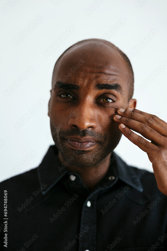 Man touching face against white background Man touching face against white background