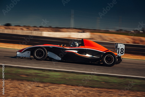 Formula car go fast at the raceway during sunset