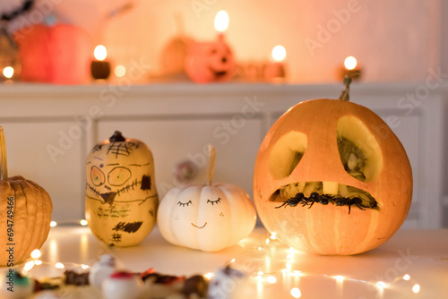 Pumpkin decorations near string light on table at home photo