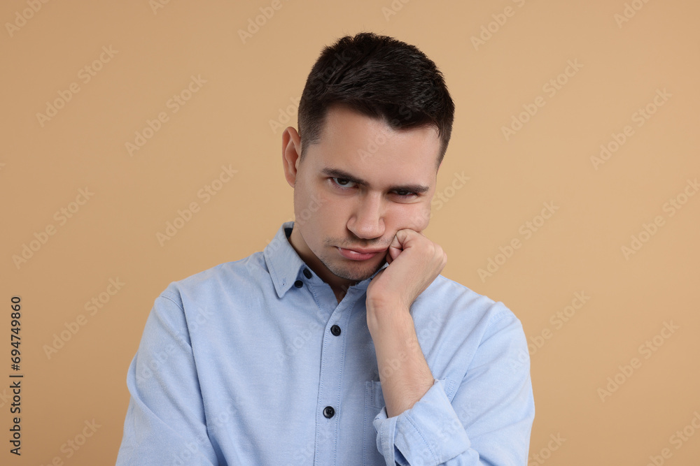 Portrait of resentful man on beige background Portrait of resentful man on beige background