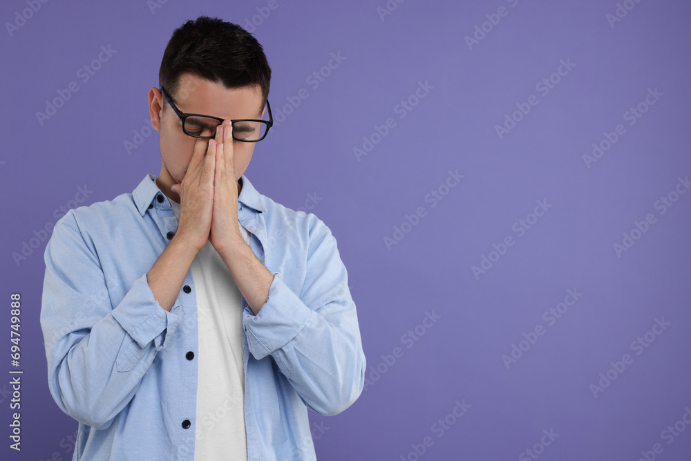 Resentful man on violet background, space for text