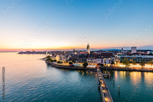 Germany, Baden-Wurttemberg, Friedrichshafen, Waterfront of city on shore of lake Bodensee at dawn photo
