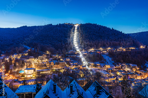 Germany, Baden-Wurttemberg, Bad Wildbad, Illuminated town in Black Forest range at winter dusk photo