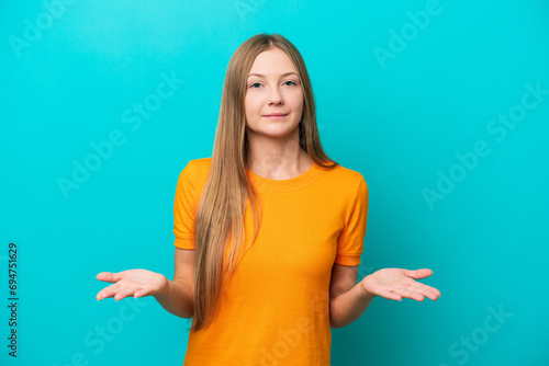 Young Russian woman isolated on blue background having doubts photo