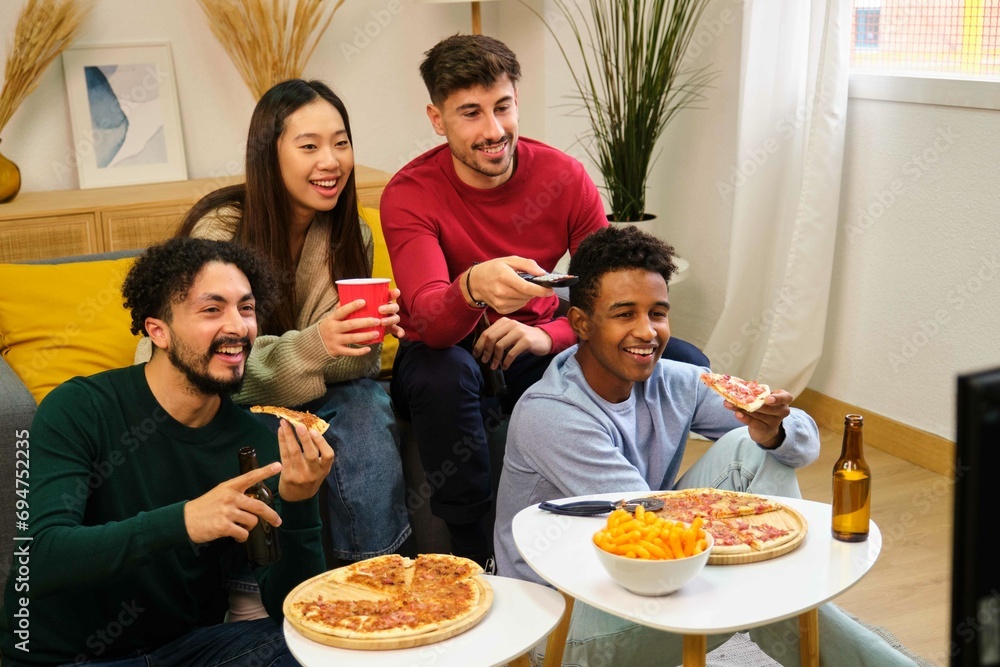 Group of friends eating pizza and watching a movie in a shared student house. Group of friends eating pizza and watching a movie in a shared student house.