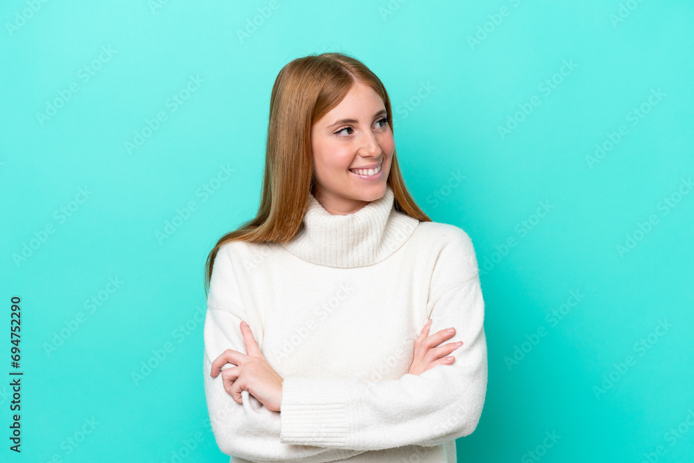 Young redhead woman isolated on blue background with arms crossed and happy Young redhead woman isolated on blue background with arms crossed and happy