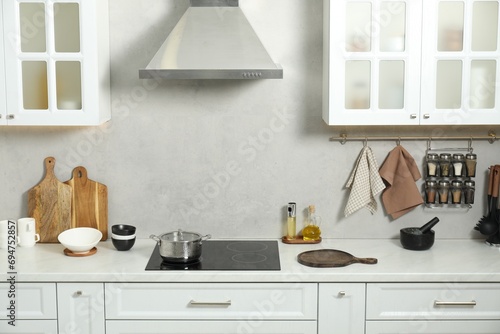 Wooden cutting boards and other cooking utensils on white countertop in kitchen © New Africa