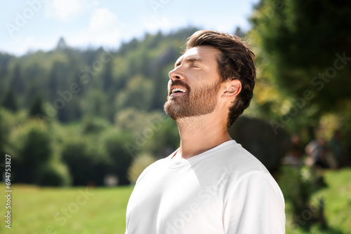 Feeling freedom. Man enjoying nature outdoors on sunny day, space for text