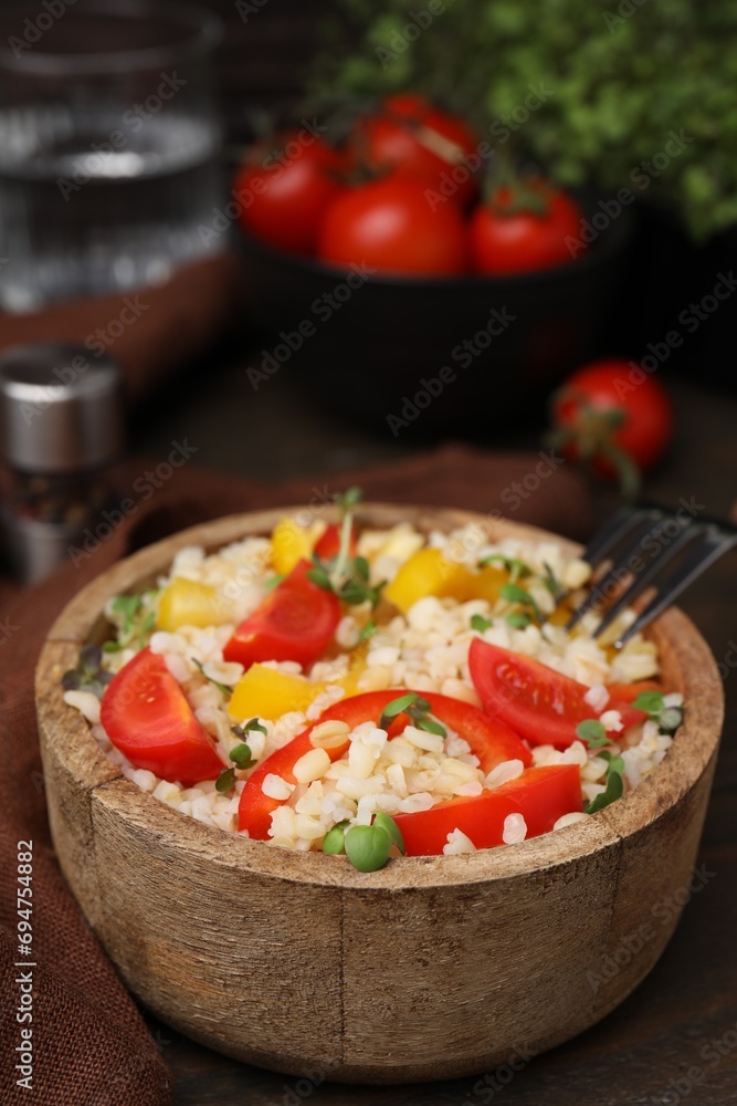 Cooked bulgur with vegetables in bowl on wooden table Cooked bulgur with vegetables in bowl on wooden table