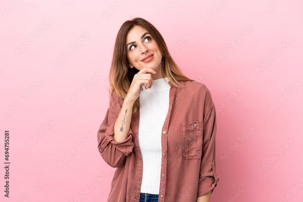 Caucasian woman isolated on pink background and looking up Caucasian woman isolated on pink background and looking up