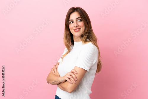 Caucasian woman isolated on pink background looking to the side and smiling © luismolinero