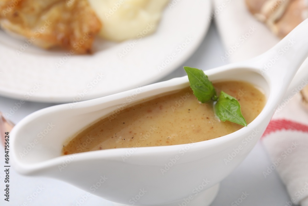 Delicious turkey gravy in sauce boat on table, closeup Delicious turkey gravy in sauce boat on table, closeup