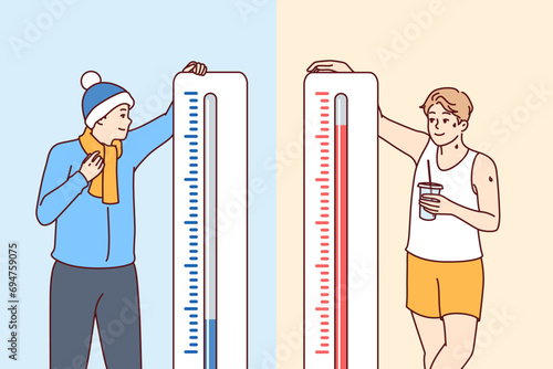 Man stands near thermometers showing different temperatures and feels heat or cold in different countries. Giant thermometers near happy guys for magazine with meteorological forecasts